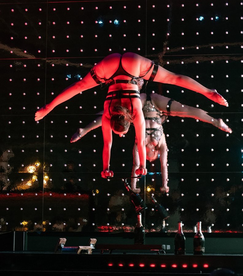 Two acrobats in a mirrored handstand on the Stable 54 stage.