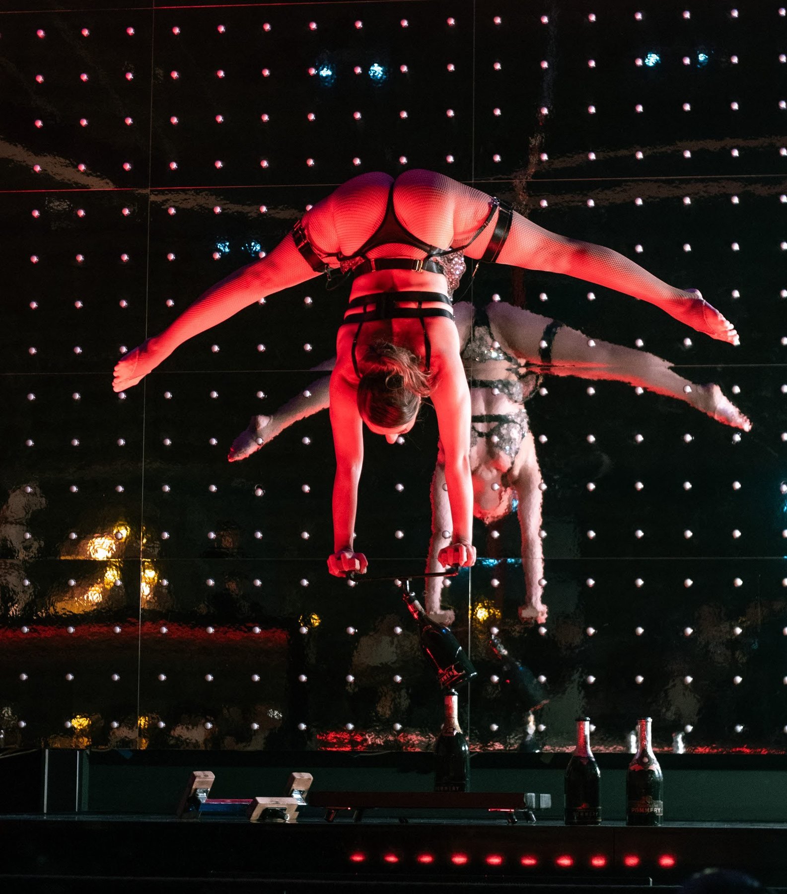 Two acrobats in a mirrored handstand on the Stable 54 stage.